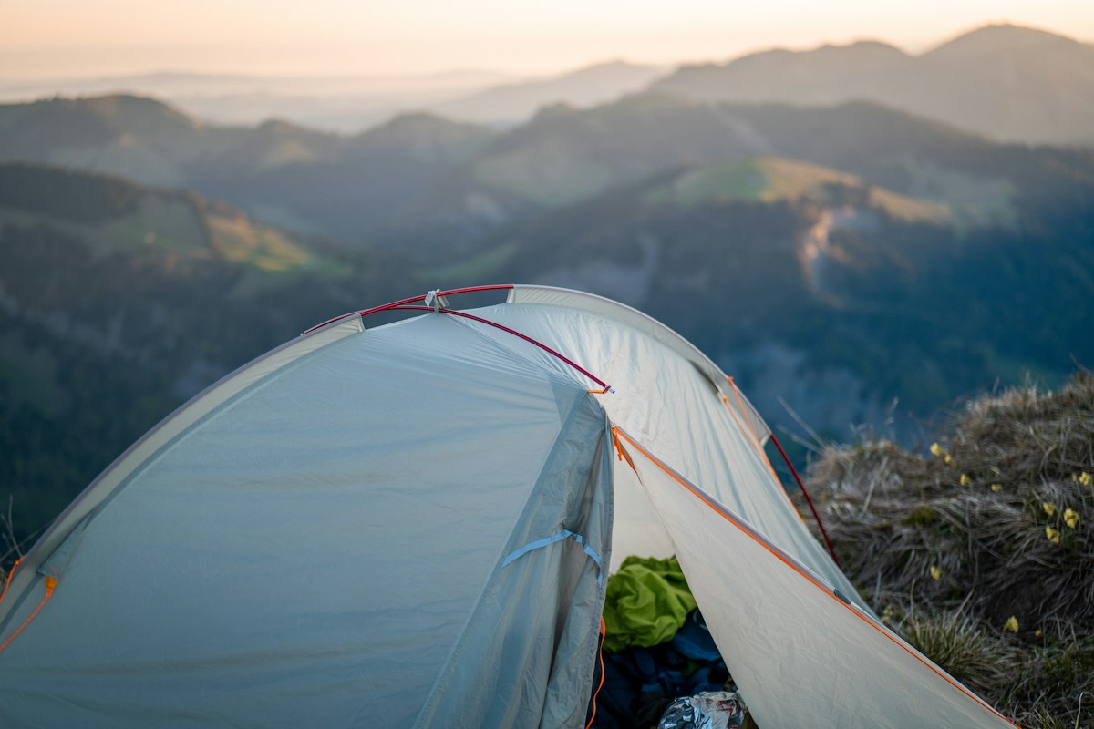 A tent overlooks mountains at sunrise